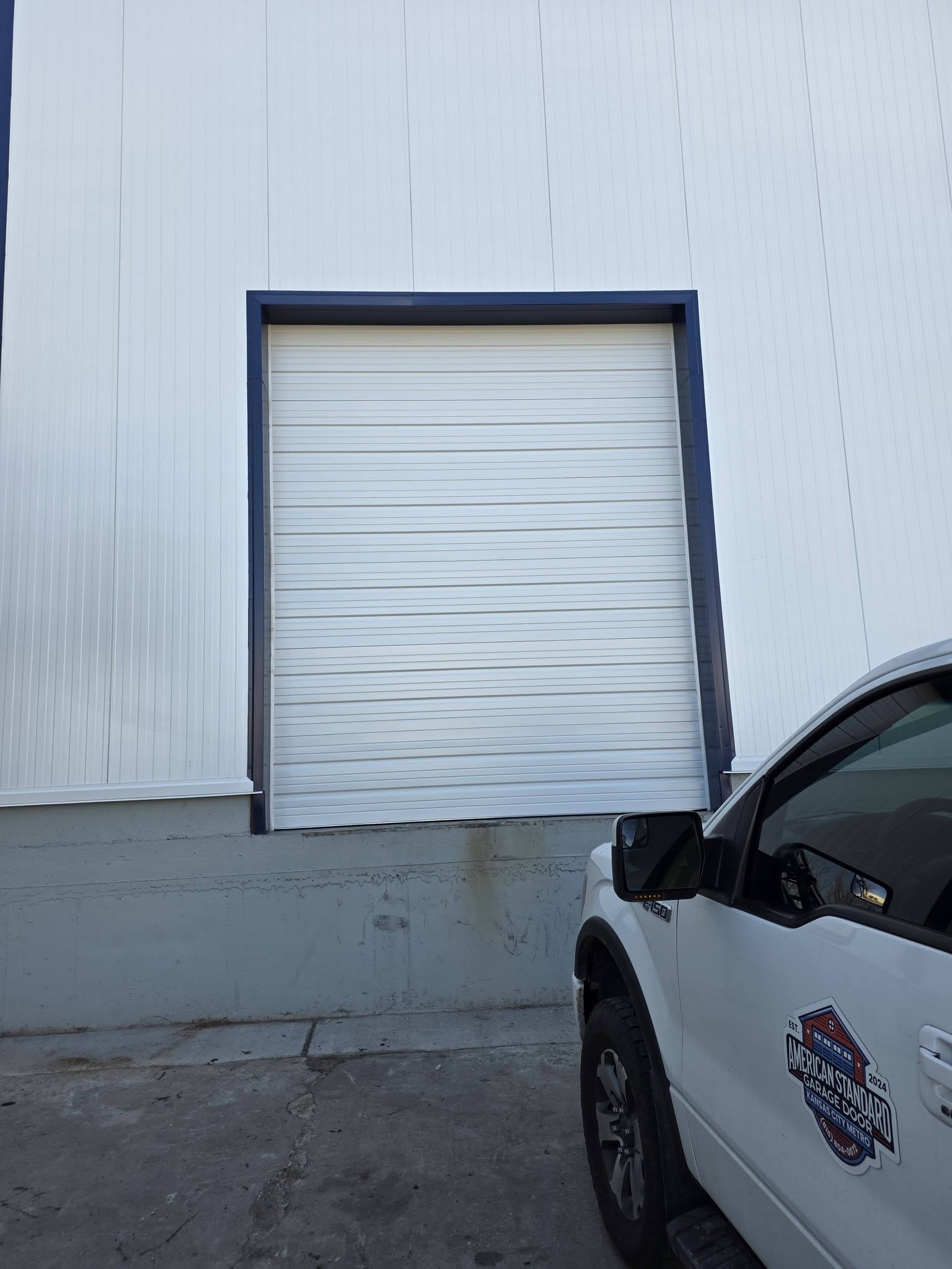 Commercial roll-up door installed with American Standard truck