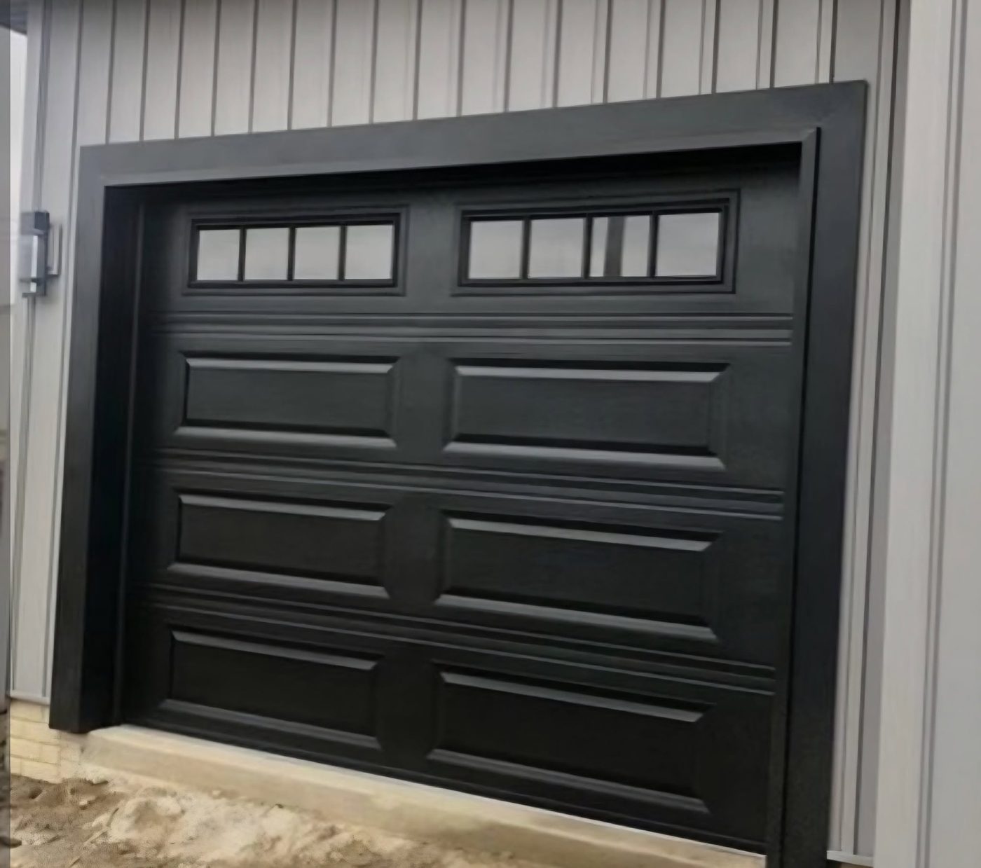 New black garage door with windows on a fresh install