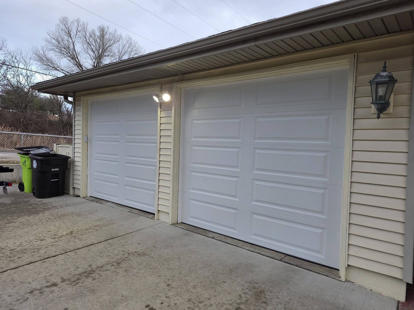 Two new white raised-panel garage doors