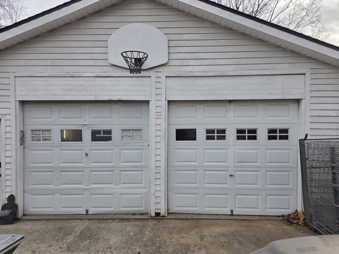 Two garage doors with window inserts on a detached garage