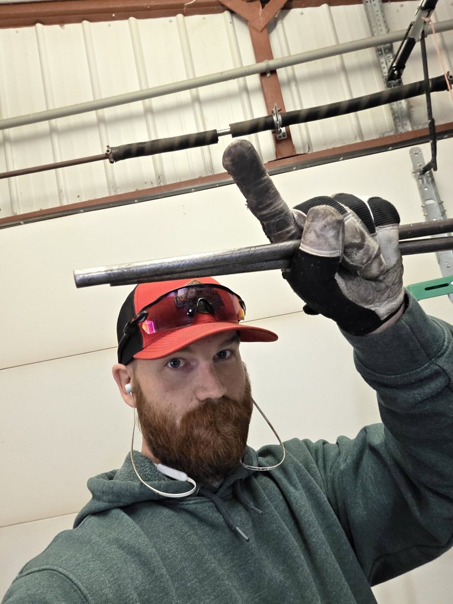Zach Wallace holding the winding bars during a torsion spring replacement